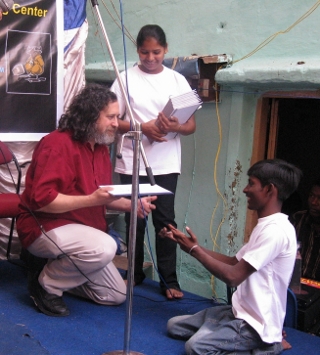 Photo d'un étudiant tendant un exemplaire de l'essai « L'avenir est à nous »
à Richard Stallman.